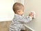 A small boy in striped clothes climbs to the outlet in the room