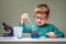 Small boy studies chemistry. Testing tubes with liquid for research. Learn for future. Biology science. Preschooler at home.