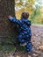 Small boy trying to climb a tree in the forest