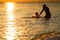 Small boy trying to swim in sea with mother