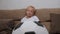 A small boy watches a football match at home sitting on the couch.