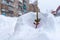 A small branch of the Christmas tree stands decorated with balloons, garlands and tinsel in a snowdrift on the street in the Russi