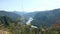 Small branches move in the wind against a blurry mountain landscape on a summer day. Mountain view of the Katun river