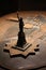 Small bronze statue of liberty on a table with a blurry background