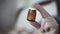 Small brown glass bottle with antibiotic pills in a female hand