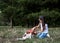 Small brunette girl with Cavalier king charles spaniel, training in park in summer. Girl, wearing blue jeans and white t-shirt,