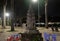 Small Buddhist altar in the park. A table and several plastic chairs. Lantern light