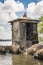A small Buddhist prayer tower on rocks in the middle of the Bentota Ganga river in the jungle on the island of Sri Lanka