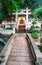 A small Buddhist temple with landscaped garden near 10000 Buddhas Monastery in Sha Tin, Hong Kong. Vertical view with stone bridge