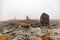 Small built stone towers among stones with moss in the foggy landscape