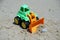 Small bulldozer toy. Bulldozer toy on a beach sand.