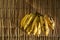 Small bunch of organically grown bananas over an background of braided straw