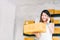 Small business owner, Asian woman hold package box, using mobile phone call receiving purchase order, working at home office