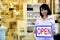 Small business owner: woman holding an open sign