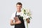 Small business, retail and employees concept. Handsome florist, salesman from flower shop handing bouquet of lilies