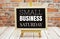 Small Business Saturday text on the blackboard set on wooden floor and brick background