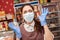 Small businesses during the pandemic. A female worker in a medical mask and rubber gloves, eyes bulging with fright, spreads her