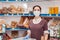 Small businesses during the pandemic. Portrait of a female worker in a medical mask and rubber gloves, working behind the counter