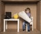 Small businessman develops building plans, cardboard office