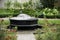 Small calm park fountain surrounded by flowers