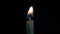 Small candle burns on a black background