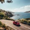 A small car journeying along a picturesque road that winds beside the stunning sea coast of the Riviera