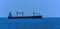 A small cargo ship at sea approaching the Singapore Straits in Asia