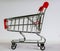 Small cart with red handle on white background. Cutest decoration. Shopping concept today.