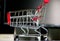 Small cart with red handle on white table background. Cutest decoration. Shopping concept today.