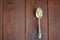 Small chamomile flowers in a melchior tea spoon on a wooden back