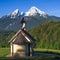 Small chapel Kirchleitn and snow-capped summits of Watzmann mountain