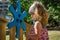 A small charming girl in a kerchief plays in a park on a playground