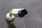 small cheap surveillance camera on tan brown granite wall