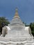 Small chedi soars in blue sky at Buddhist temple