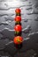 Small cherry tomato on a black background with water