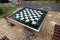 A small chess table in the park. Empty board game table