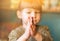 A small child asks. The baby girl clasped her hands together for prayer and supplication. Blurry Funny cute little girl praying at