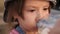 A small child drinks clean water from a bottle for health. The girl quenches her thirst. Kid in the park. Close-up