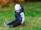 A small child falls asleep sitting in the grass