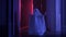 Small child in ghost costume is having fun and dancing indoors in rays of moonlight. Halloween ghost costume made of