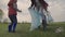 A small child with his parents collects trash in a park recreation area, group cleaning of the territory, ecology of