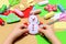 Small child holding a felt Christmas snowman in hands. Little kid shows Christmas ornament crafts. Workplace in kindergarten