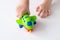 A small child holds a green toy airplane. The concept of imagination, children`s games, travel, leisure, tourism