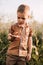 A small child holds a snail in his hands and carefully examines it