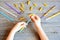 Small child holds straw and dried tube pasta in his hands. Child stringing pasta onto straw