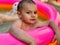 A small child in an inflatable kids round pool in sunny summer weather