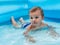 A small child in an inflatable kids round pool in sunny summer weather