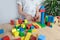 Small child, kid plays with colored wooden cubes, builds houses and rockets, the concept of the development of creativity, fine