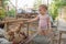 A small child is looking at chickens and a rooster in a chicken coop on a farm and feeds chickens with cucumbers