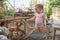 A small child is looking at chickens and a rooster in a chicken coop on a farm and feeds chickens with cucumbers